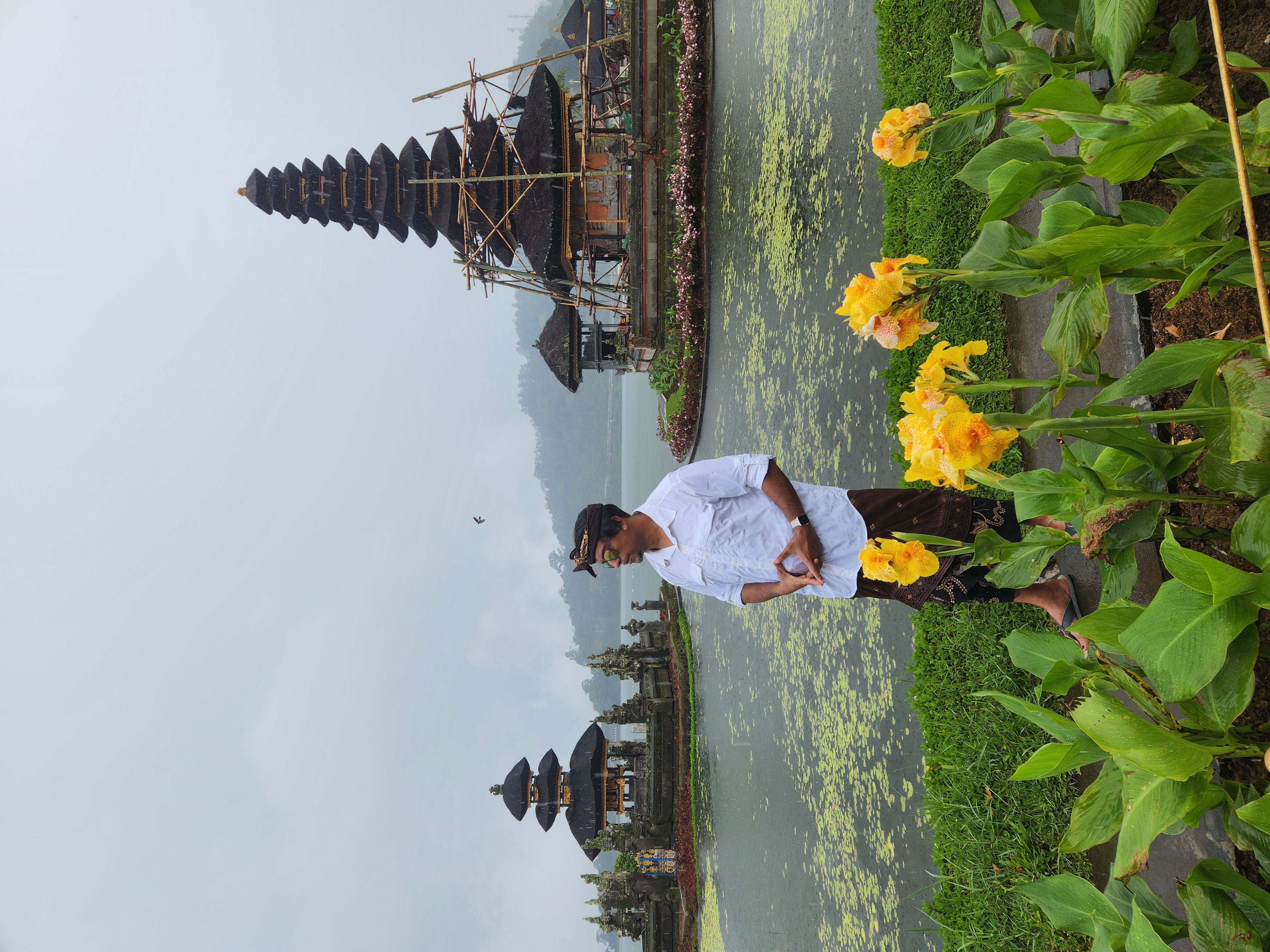 Man in traditional Balinese dress before Ulun Danu Beratan water temple on Lake Bratan